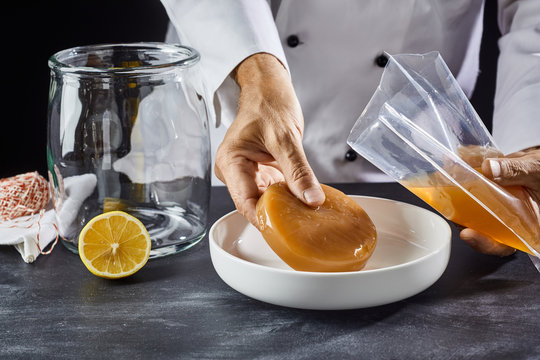 Man placing a scoby in a dish for activation