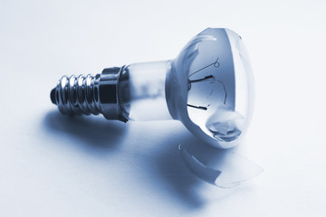 Broken incandescent light bulb, blue toning of photo.