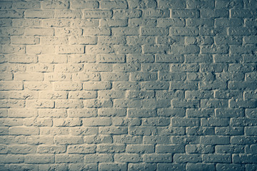 Part of a brick stone wall with illumination.