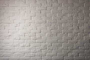 Part of a brick stone wall with illumination. Surface of the brick wall which is brightly illuminated on the one hand. The image has not contrast color scale...