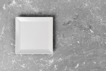 empty square plate on textured dark background