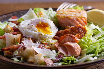 Salmon caesar salad. Crispy pan fried salmon fillet, bacon, poached egg, lettuce and croutons dressed with parmesan cheese