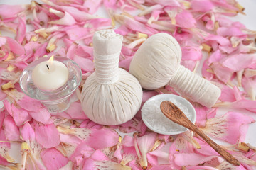 Pile of many pink petals background with and herbal ball,candle,salt spoon in bowl 