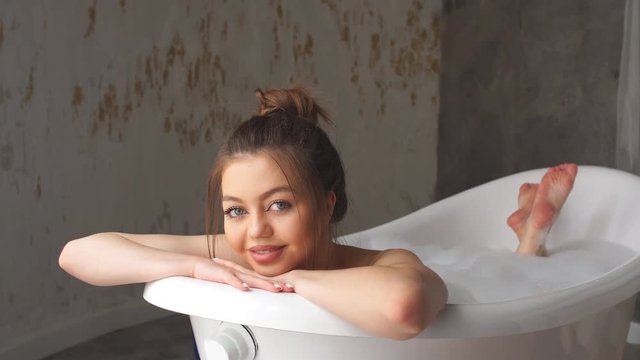 moden bathroom is occupied by a pleasant girl with brown hair. refreshing dip