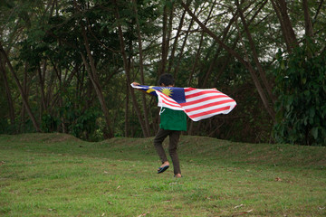 Independence Day concept. A happy bog holding Malaysian flag.