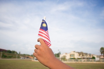 Independence Day concept. A happy and proud boy holding Malaysian flag.