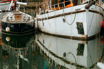 Fototapeta na wymiar Luxury yachts moored in marina. Boats reflected in the water of Honfleur harbor, Upper Normandy, France. Close up. Yachting, vacation, luxury lifestyle and wealth concept