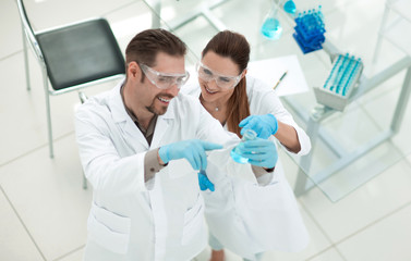 top view.a pair of technicians looking at the tube with the liquid