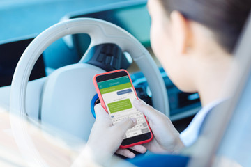 Online messaging. Nice young woman holding her smartphone while talking online