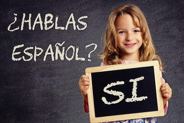 Kind hält Schild Hablas Español? Si 
