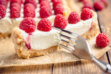 Fresh raspberry cheesecake on the rustic background. Selective focus. Shallow depth of field.