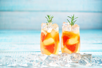 Gin cocktail with rosemary and grapefruit on a turquoise background,selective focus.