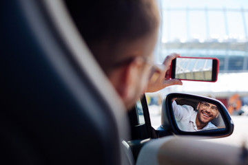 Beautiful view. Happy nice man taking a photo while driving in the car