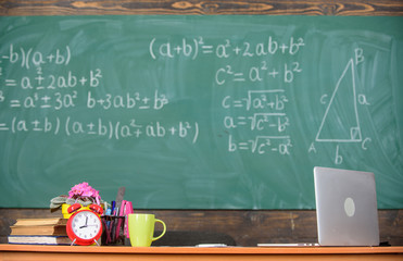 Teachers attributes. Table with school supplies alarm clock books and mug classroom chalkboard background. Working conditions which prospective teachers must consider. Traditional teachers workplace