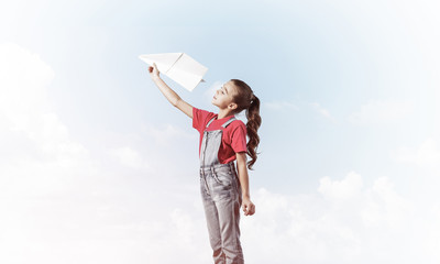 Concept of careless happy childhood with girl dreaming to become