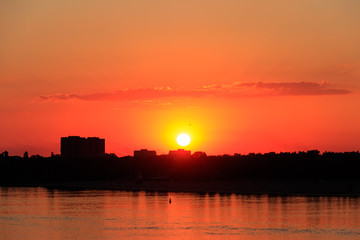 Fototapeta na wymiar Orange sunset over a river Dnieper in Kremenchug city, Ukraine