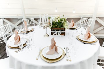 Serving tableware on a round table with fresh flowers