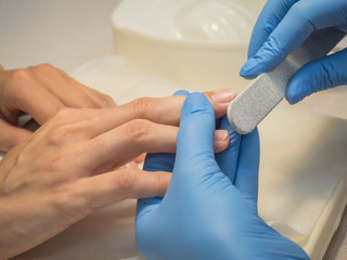 Obraz premium Manicure procedures. Correction of the nail shape in the nail salon.