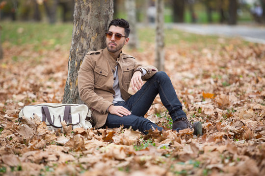 Young adult man handsome posing in the wood, winter autumn day