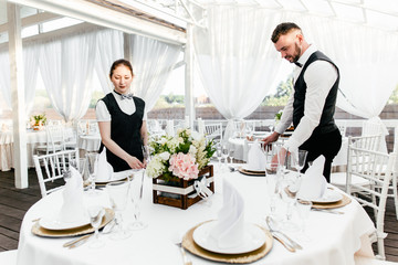 Two waiters serve a round table in the restaurant