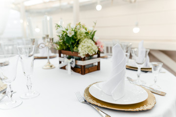 Serving tableware on the table with fresh flowers