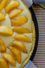 close up of peach tart with cream before baking