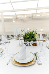 Table setting on a white tablecloth in the restaurant close-up