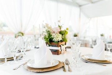 Table setting with fresh flowers on a white tablecloth in the restaurant close-up