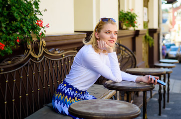 Whom should I call. Woman curious face sit with smartphone cafe terrace urban background. Lady...