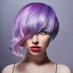 Portrait of a woman with bright colored flying hair, all shades of purple. Hair coloring, beautiful...