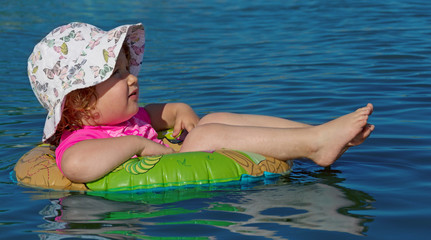 Kleinkind schwimmt auf Schwimmring im Wasser 2