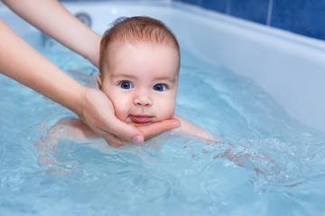 Fototapeta na wymiar baby boy swimming in the bath