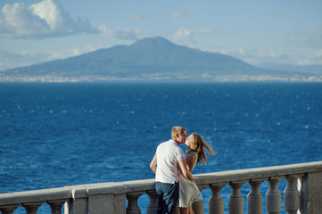Young romantic couple on a background of a sea landscape and Vesuvius, Naples, Italy - travel concept