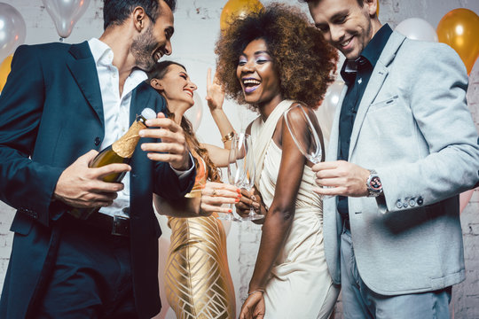 Man Opening Champagne Bottle On Celebration For New Years Eve Or Birthday In Club