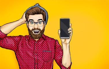 Attractive smiling hipster in specs with phone in the hand in comic style. Pop art man in hat holding smartphone. Digital advertisement male model showing the message or new app on cellphone.  - obrazy, fototapety, plakaty