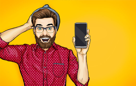 Fototapeta Attractive smiling hipster in specs with phone in the hand in comic style. Pop art man in hat holding smartphone. Digital advertisement male model showing the message or new app on cellphone. 