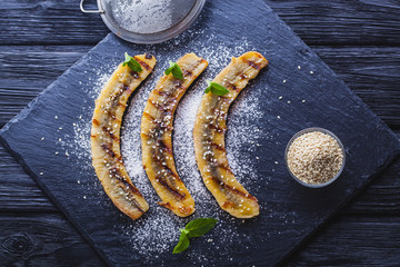 Sweet fried banana served on a black slate board