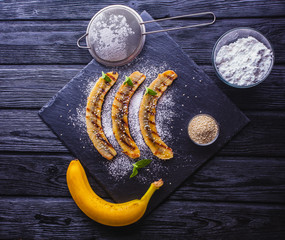 Sweet fried banana served on a black slate board