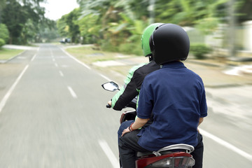 Portrait of motorcycle taxi driver delivering the passenger to his destination