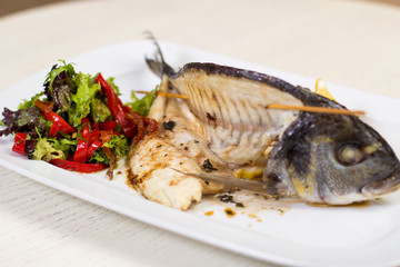 Fried fish with salad on a white dish