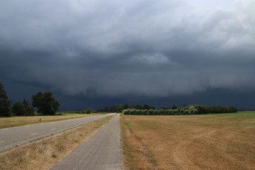 Fototapeta na wymiar Big wall cloud above the fields in Overijssel in the Netherlands with thunderstorms coming up