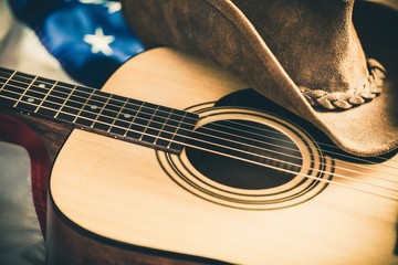 Acoustic Guitar and Cowboy Hat with American Flag on Background