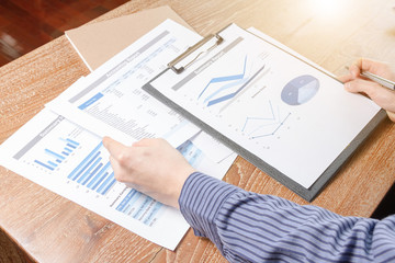 Fototapeta premium business man analyzing graph and chart document report