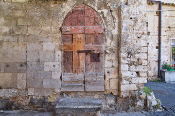 Fototapeta na wymiar Ancient wooden door with a stone porch