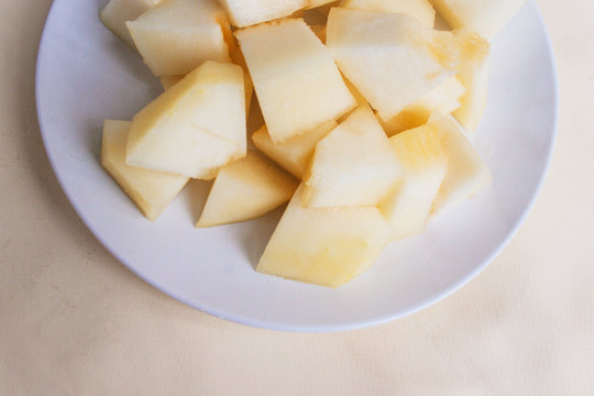 Pieces of melon on a  plate half . View from above, candid.