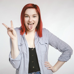 Red haired plus size ordinary woman standing on a neutral grey background. Emotional portrait. She...