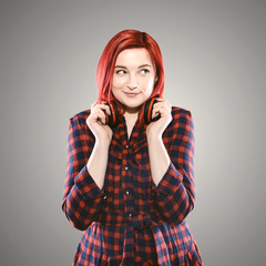 Red haired plus size ordinary woman standing on a neutral grey background. Emotional portrait. She...