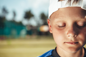 Close up face of small boy demonstrating quiet while locating outdoor. Copy space