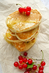 Delicious homemade pancakes with honey and red currants. View from above.