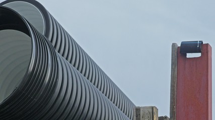 Naklejka premium Warehouse of finished plastic pipes industrial outdoors storage site. Manufacture of plastic water pipes factory. Process of making plastic tubes on the machine tool with the use of water and air